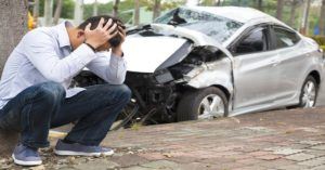 Man kneeling after a car accident